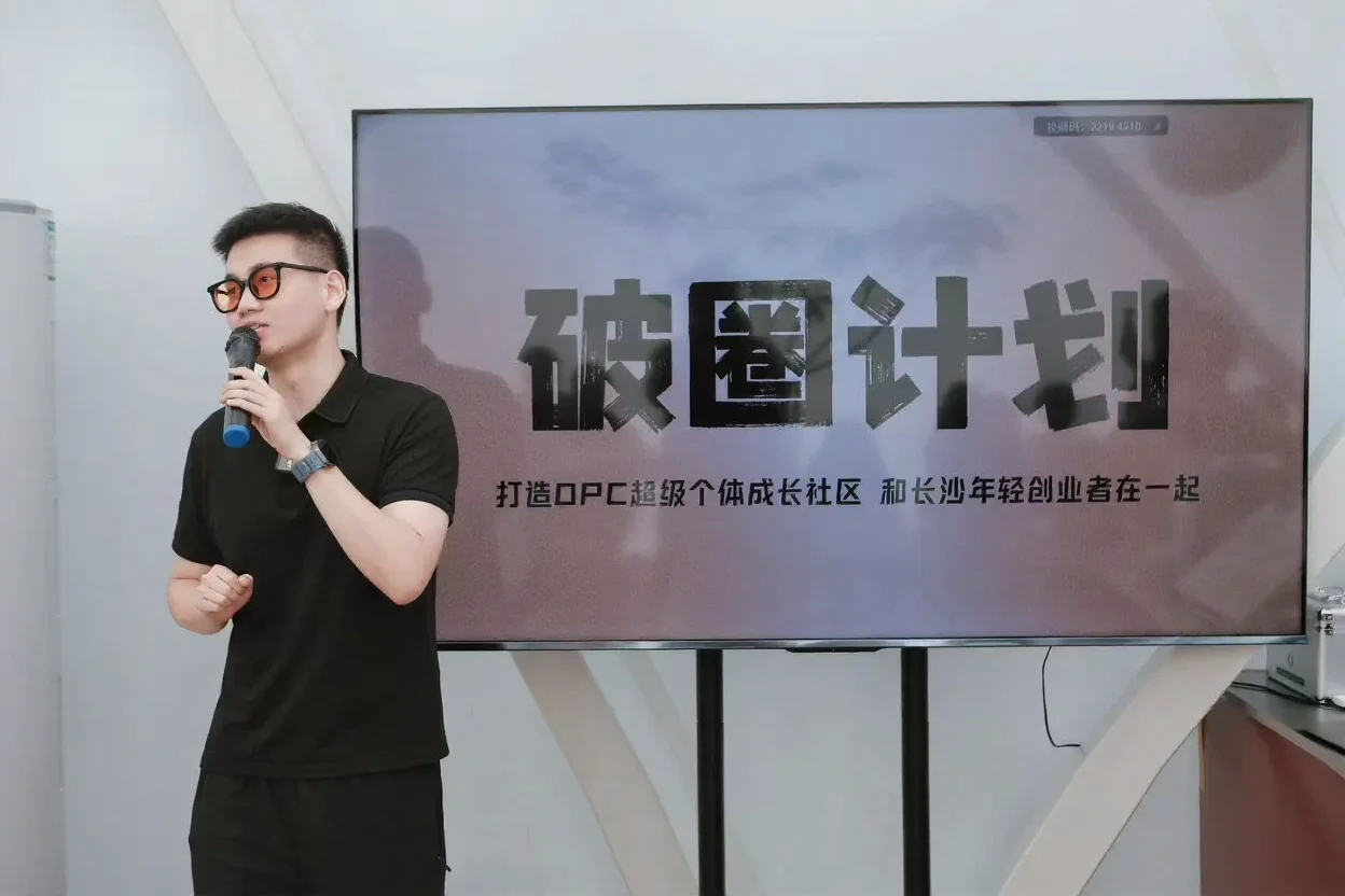 破圈创业开放麦现场,一位演讲者持麦分享,背板为破圈计划主视觉